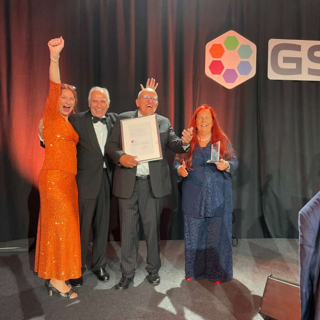 Gruppenfoto auf einer Bühne bei einer Hall-of-Fame-Aufnahme mit Urkunde